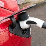 Electric,Car,With,Raindrop,In,Red,Is,Charged,With,Plug